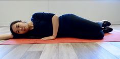 a woman laying on top of a yoga mat