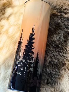 a black and orange vase sitting on top of a fur covered floor next to a tree