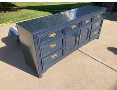 a blue dresser sitting on top of a sidewalk