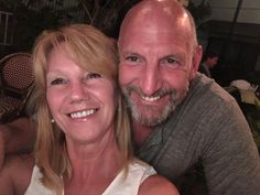 a man and woman posing for a photo at an outdoor restaurant with their arms around each other