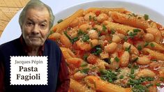 an old man sitting in front of a plate of pasta