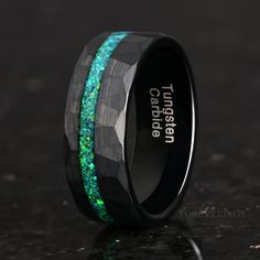 a black ceramic ring with green and blue inlays