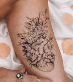 a woman's arm with flowers and a heart tattoo on the left side of her body