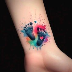 a small foot tattoo with watercolor splashs on it