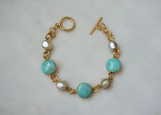 Vintage Circa 1970 in an Ancient Roman Style Constructed of Sterling Silver Accented with a Gold Plating / Vermeil  Containing 3 Round pieces of Genuine Earth-Mined Natural Turquoise ranging from approximately 11.3mm-12mm in diameter spaced with 4 Natural Freshwater Pearls ranging from approximately 7.2mm-8.1mm in length *See photo next to U.S. DIME & QUARTER for size reference as well.. Bracelet measuring approximately 7" in length --Shown on a 6" wrist in natural daylight/sunlight-- Weighing 1 Luxury Handmade Turquoise Bracelets, Luxury Handmade Turquoise Bracelet, Handmade Elegant Turquoise Pearl Bracelet, Elegant Handmade Turquoise Pearl Bracelet, Roman Style, Roman Fashion, Bracelet Vintage, Silver Accents, Natural Turquoise