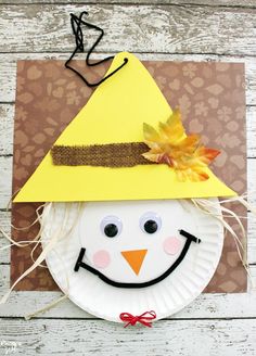 a paper plate snowman with a yellow hat on it's head and the words scarecrow paper plate craft