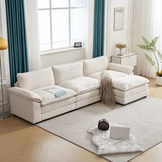 a white couch sitting on top of a rug in a living room next to a window