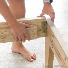 a person standing on top of a piece of wood with their foot on a bench