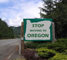 a green and white sign that says stop moving to oregon on the side of the road