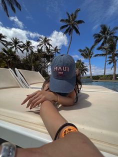 a woman sitting on the back of a boat with her arm around another person's hand