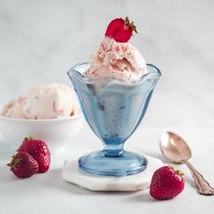 two bowls of ice cream with strawberries on the side