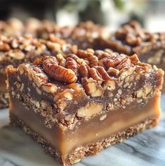 two pieces of pecan bar sitting on top of a marble counter