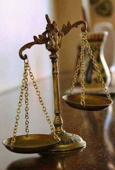 two golden scales sitting on top of a wooden table