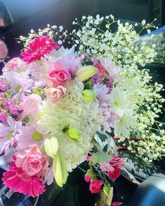 a bouquet of flowers sitting on the dashboard of a car