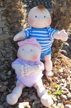 two stuffed animals sitting next to each other on the ground