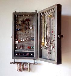 an open metal box with jewelry hanging on it