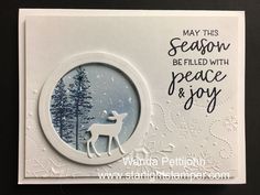 a christmas card with a deer and snowflakes on the front, and an ornament in the middle