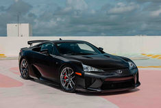 a black sports car parked on top of a parking lot