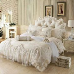 a white bed sitting in a bedroom on top of a hard wood floor next to a dresser