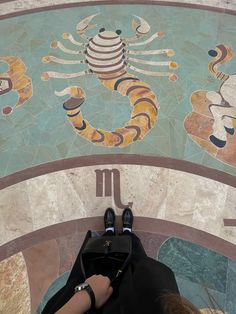 a person laying on the ground in front of a colorful wall with scorpions painted on it