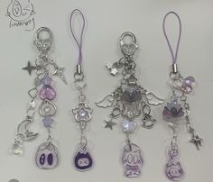 three charms are hanging on a white surface with purple string and beads in the shape of cartoon characters