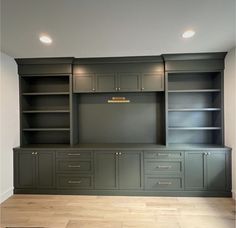 an empty room with built - in cabinets and cupboards on the wall, along with hard wood flooring