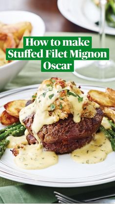 a white plate topped with steak covered in gravy and asparagus next to fries