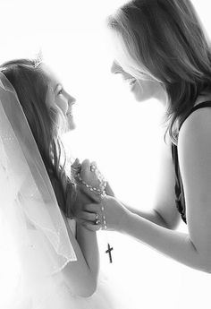 two beautiful young women standing next to each other in front of a white wall holding hands