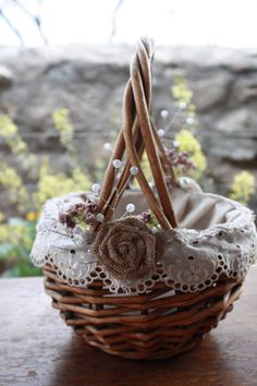 a wicker basket with lace and flowers in it