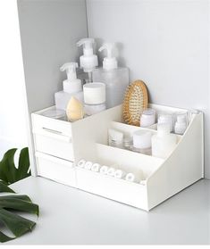 a white drawer with soaps, toothbrushes and lotion bottles in it