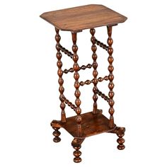 an old wooden table with chains on the legs and a small square top that has been turned into a side table