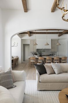 a living room filled with furniture and a chandelier hanging over the top of it