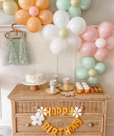 a birthday party with balloons, cake and cupcakes