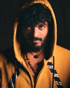 a man wearing a yellow hoodie with a beard