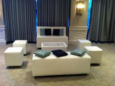 a living room with white furniture and blue curtains