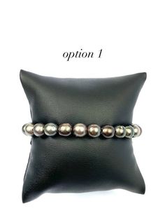 Beautiful leather Tahitian pearl beaded bracelet that is adjustable - Below are the measurements of each bracelet - Option 1 pearl size: 7.70mm - 8.05mm Option 2 pearl size: 7.05mm - 8.10mm Option 3 pearl size: 7.70mm - 7.85mm Option 4 pearl size: 7.50mm - 7.85mm Option 5 pearl size: 7.00mm - 7.95mm - Option 1 # of pearls: 23 Option 2 # of pearls: 22 Option 3 # of pearls: 24 Option 4 # of pearls: 24 Option 5 # of pearls: 22 - Option 1: 7.5 inches long Option 2: 7.5 inches long Option 3: 7.5 inch Formal Adjustable Single Strand Beaded Bracelets, Adjustable Single Strand Beaded Bracelet For Formal, Formal Adjustable Single Strand Pearl Bracelet, Adjustable Single Strand Pearl Bracelet, Adjustable Luxury Pearl Bracelet, Luxury Adjustable Round Pearl Bracelet, Tahitian Pearl Bracelet, Pearl Beaded Bracelet, Pearl Jewelry Design