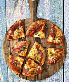 a wooden cutting board topped with slices of pizza