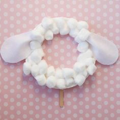 a cotton wreath on top of a pink polka dot tablecloth with a toothpick in the middle