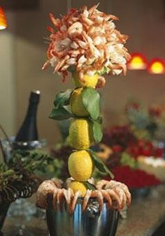 a vase filled with flowers and lemons on top of a table