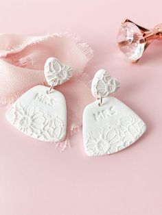 Discover Mrs. Earring, the perfect choice for bachelorette party jewelry for the bride to be. These handmade clay bridal earrings feature white floral dangles, making them an ideal bridal shower gift. ✨Earring Details✨ - Polymer clay - Earring posts are stainless steel & hypoallergenic - Lightweight Want to see more of our bridal earrings? Click the link ⬇ https://www.etsy.com/shop/Wild4Style?ref=seller-platform-mcnav&section_id=43807854 📦Shipping & Packaging📦 All orders will be packaged securely to ensure a safe delivery. Orders will be processed and shipped within 1-7 business days.  If you need it sooner, I provide a rush order option.  The rush order option, expedites the processing and shipping to 1-3 business day.  If you would like to add this to your order, click the link below. Bridal Clay Earrings, Clay Earrings Wedding, Jewelry For Bride, Earring Bridal, Bridal Earring, Earrings Ideas, Clay Earring, Shipping Packaging, Bridal Shower Gift