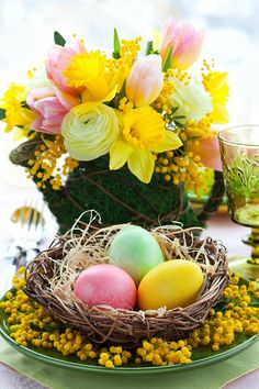 an easter centerpiece with flowers and eggs