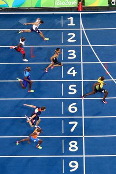 the athletes are competing in a race on the blue track at the olympic games,