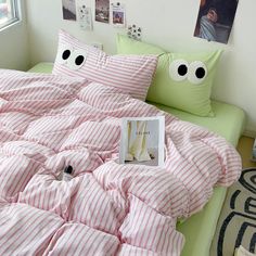 a bed covered in pink and white striped sheets with eyeballs on the pillow cases