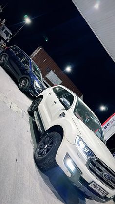 two white trucks parked next to each other