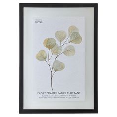 a white framed print with leaves on the bottom and black frame, in front of a white background