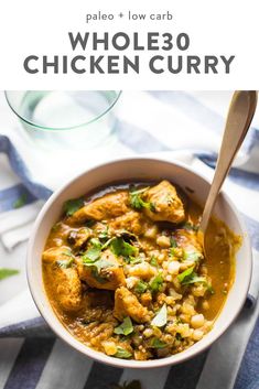 a white bowl filled with chicken curry and garnished with cilantro