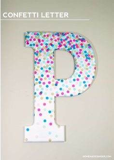 the letter p is made out of polka dot paper and sits on top of a white wall