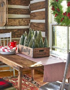 a wooden table topped with christmas trees next to a window