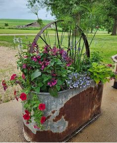 an old metal planter with flowers in it