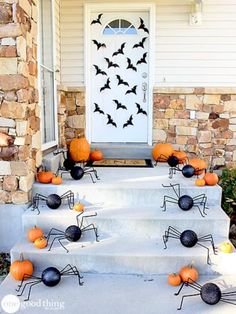 an image of halloween decorations on the front steps with bats and pumpkins around them